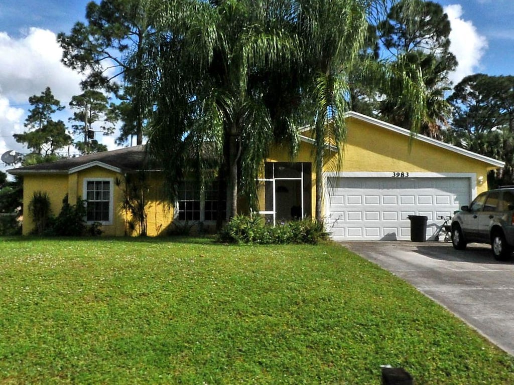 ranch-style home with a front lawn and a garage