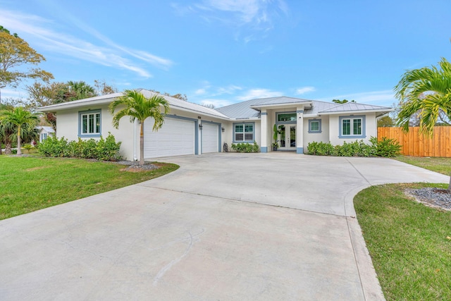 single story home featuring a front yard, french doors, and a garage