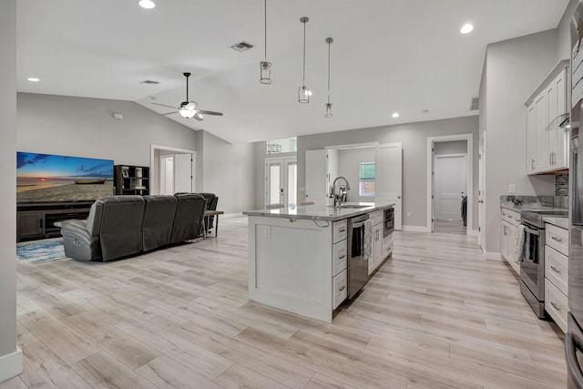 kitchen featuring visible vents, hanging light fixtures, vaulted ceiling, stainless steel appliances, and a sink