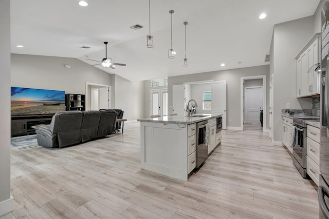 kitchen with stainless steel appliances, lofted ceiling, visible vents, light wood-style floors, and a sink