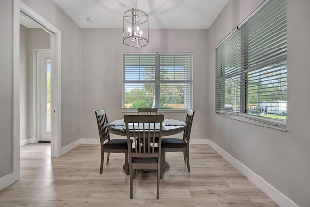 dining room with plenty of natural light, baseboards, and light wood-style flooring