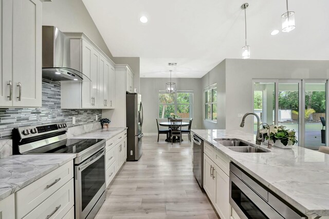 kitchen featuring stainless steel appliances, sink, white cabinets, and a kitchen island with sink