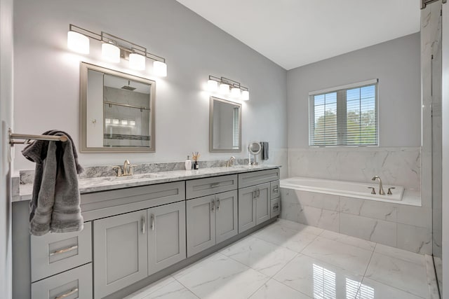 bathroom with double vanity, a shower, marble finish floor, a garden tub, and a sink