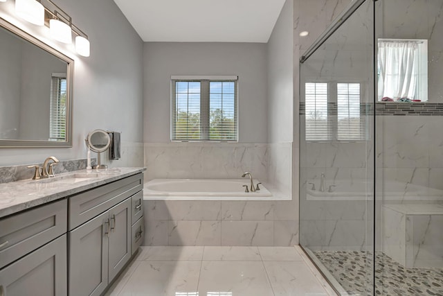 full bath featuring vanity, plenty of natural light, a marble finish shower, and a bath