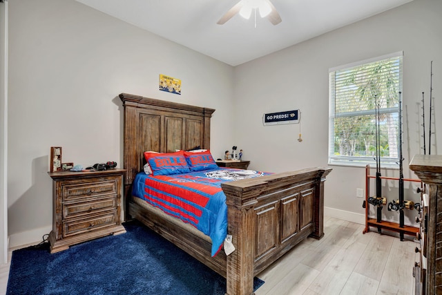 bedroom with light wood-style floors, baseboards, and a ceiling fan