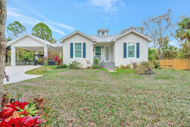 view of front of house with driveway, metal roof, an attached carport, fence, and a front lawn