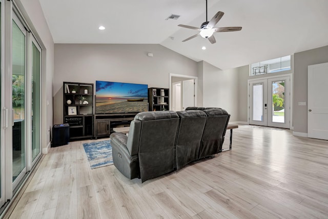 living room with baseboards, lofted ceiling, ceiling fan, french doors, and light wood-type flooring