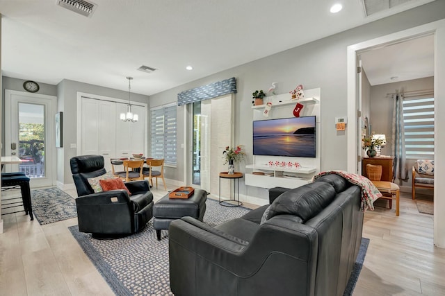 living room featuring a notable chandelier and light hardwood / wood-style flooring