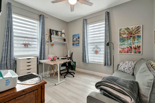 home office featuring light wood-type flooring, ceiling fan, and baseboards