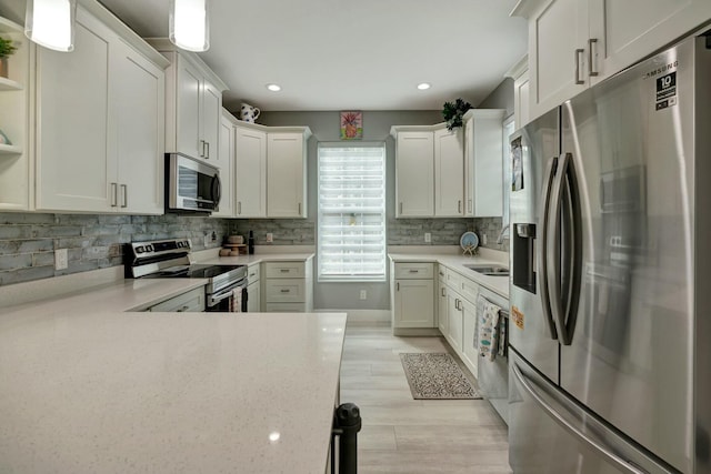 kitchen featuring recessed lighting, light wood-style floors, appliances with stainless steel finishes, decorative backsplash, and open shelves