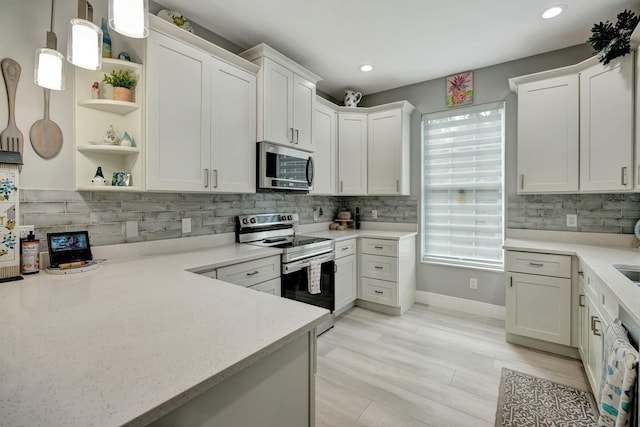 kitchen with decorative backsplash, appliances with stainless steel finishes, decorative light fixtures, white cabinetry, and open shelves