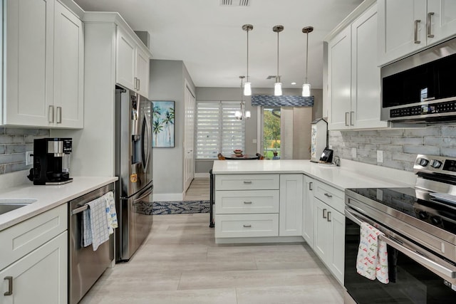 kitchen with a peninsula, visible vents, white cabinets, light countertops, and appliances with stainless steel finishes