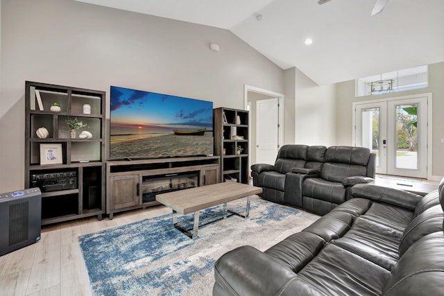 living room featuring light hardwood / wood-style floors, ceiling fan, french doors, and vaulted ceiling