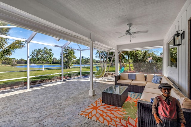 sunroom featuring a water view and ceiling fan