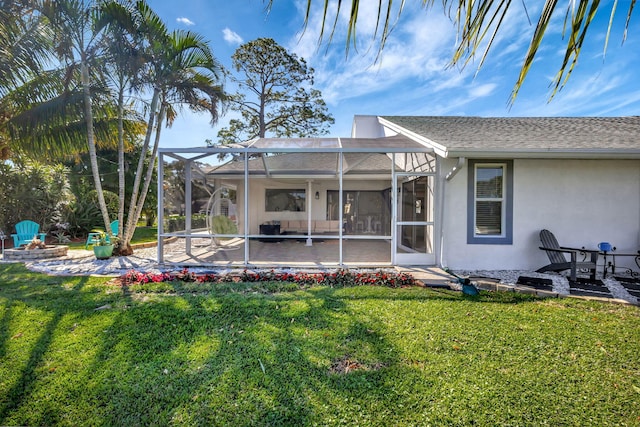 rear view of house featuring an outdoor fire pit, a lanai, a patio, and a lawn