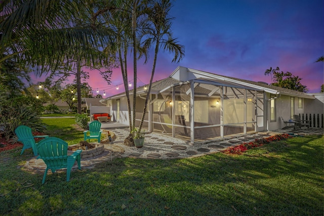 exterior space featuring a yard, glass enclosure, and a patio area