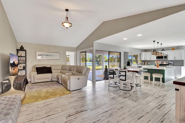 living room featuring lofted ceiling and plenty of natural light