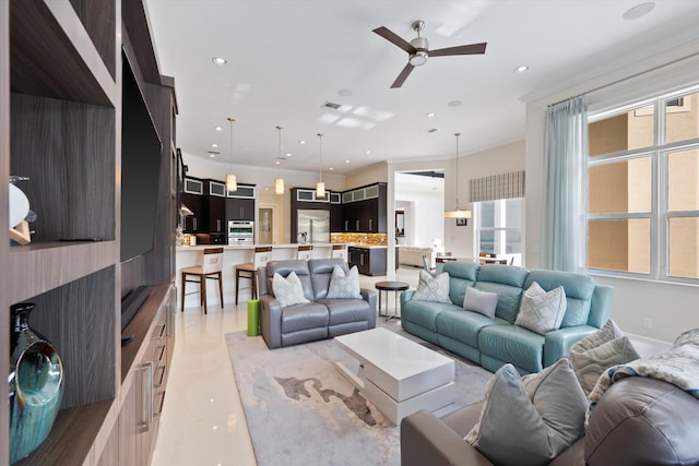 tiled living room featuring ceiling fan and ornamental molding