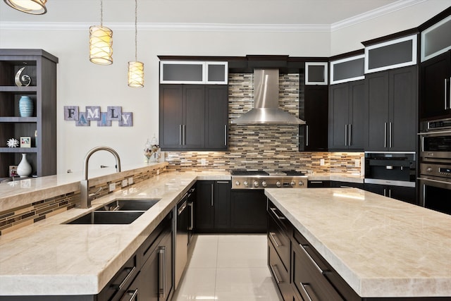 kitchen featuring decorative light fixtures, sink, backsplash, and wall chimney range hood