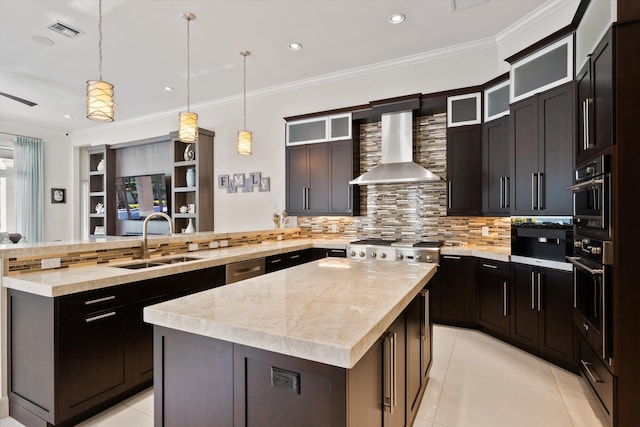 kitchen with kitchen peninsula, hanging light fixtures, a kitchen island, wall chimney exhaust hood, and sink