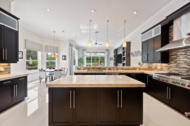 kitchen featuring ceiling fan, a kitchen island, decorative backsplash, and decorative light fixtures