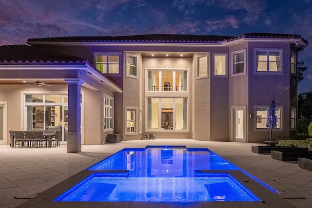 back of property with a swimming pool with hot tub, a patio area, and ceiling fan