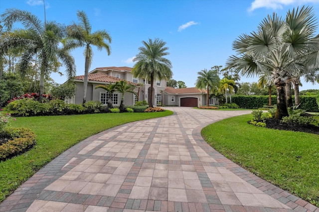 mediterranean / spanish-style home with a front yard and a garage