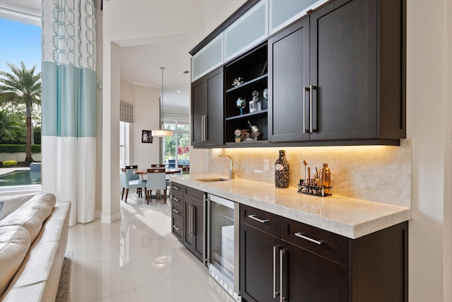 bar featuring light tile patterned floors, backsplash, wine cooler, pendant lighting, and sink