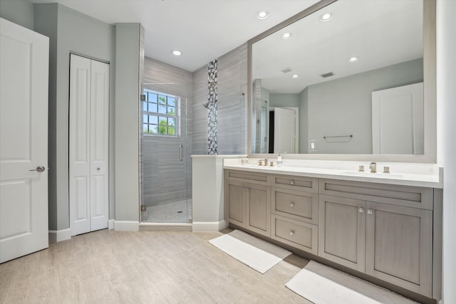 bathroom featuring a shower with door, hardwood / wood-style flooring, and vanity