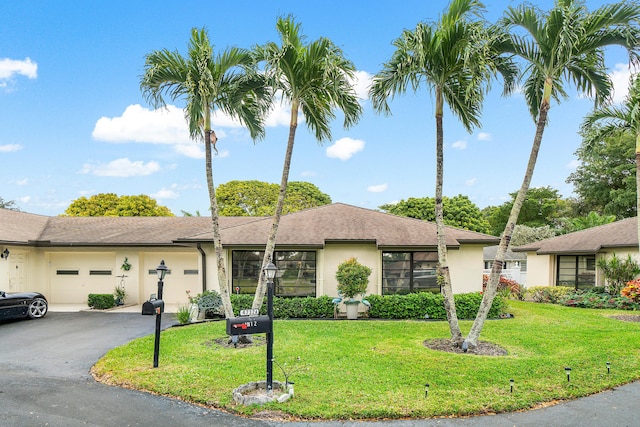 single story home featuring a front yard and a garage