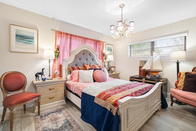 bedroom with an inviting chandelier and light hardwood / wood-style flooring