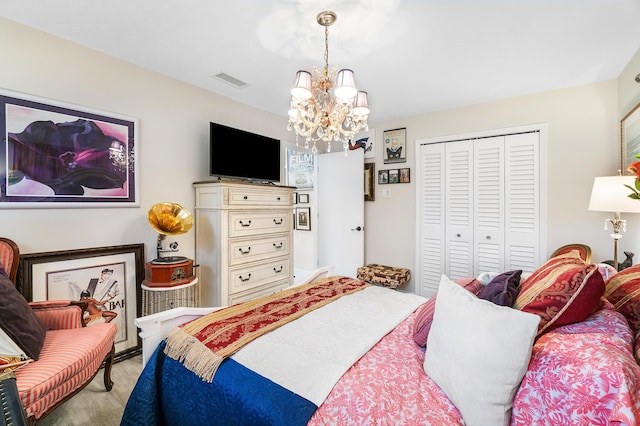 bedroom with an inviting chandelier and a closet