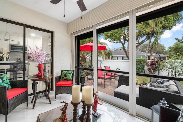 sunroom / solarium featuring ceiling fan