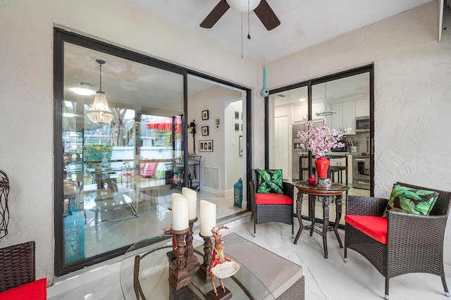 interior space with ceiling fan with notable chandelier