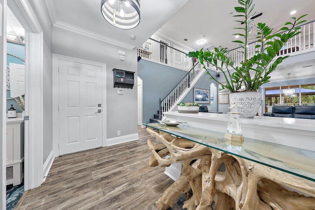 dining room with hardwood / wood-style floors, crown molding, and a chandelier