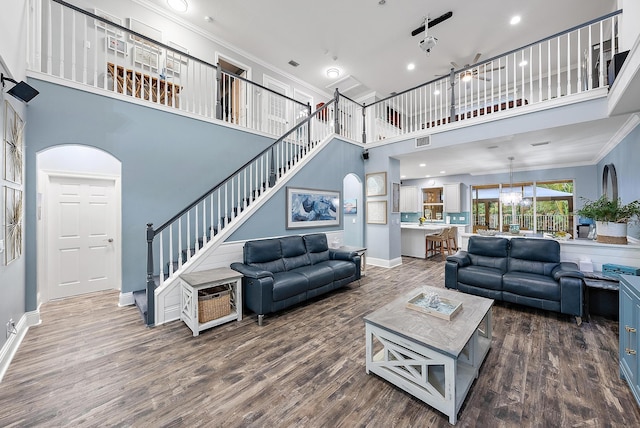 living room featuring ornamental molding, dark hardwood / wood-style flooring, and a towering ceiling