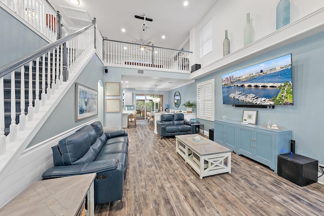 living room featuring a towering ceiling and hardwood / wood-style flooring