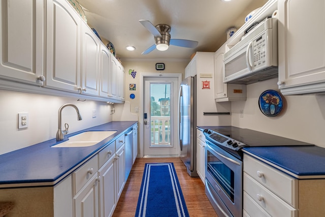 kitchen with dark hardwood / wood-style floors, appliances with stainless steel finishes, white cabinets, and sink