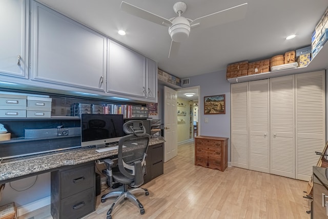 office space with ceiling fan, light hardwood / wood-style flooring, and built in desk