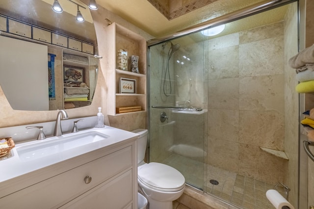 bathroom with toilet, a shower with shower door, and vanity