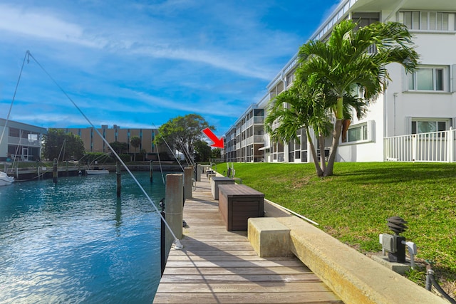 dock area with a lawn and a water view