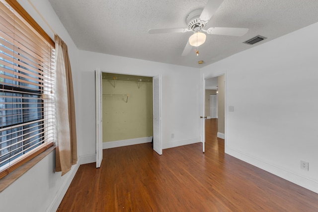 unfurnished bedroom featuring ceiling fan, wood-type flooring, a closet, and a textured ceiling