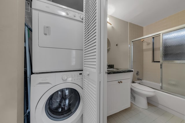 washroom with light tile patterned flooring and stacked washer / drying machine