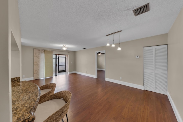 spare room featuring dark hardwood / wood-style floors and a textured ceiling