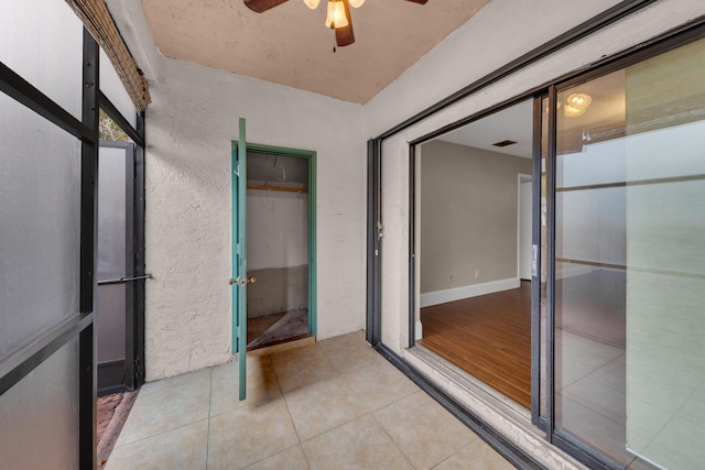 interior space with tile patterned floors and ceiling fan