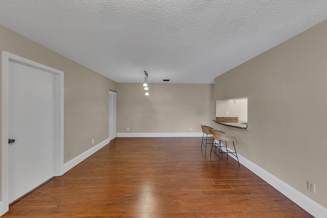 empty room featuring dark hardwood / wood-style flooring and a textured ceiling