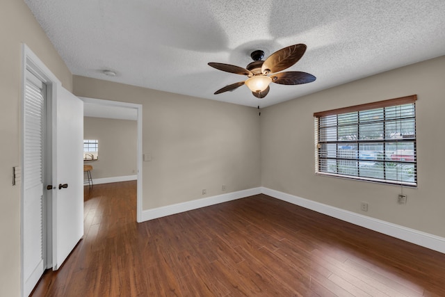 empty room featuring ceiling fan, dark hardwood / wood-style floors, and a textured ceiling