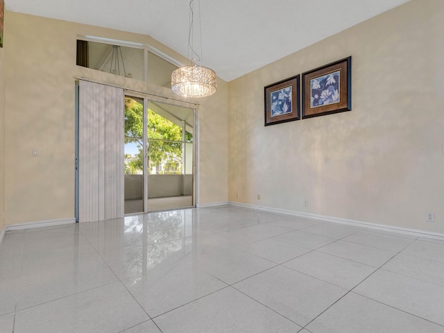 spare room with light tile patterned floors, lofted ceiling, and an inviting chandelier