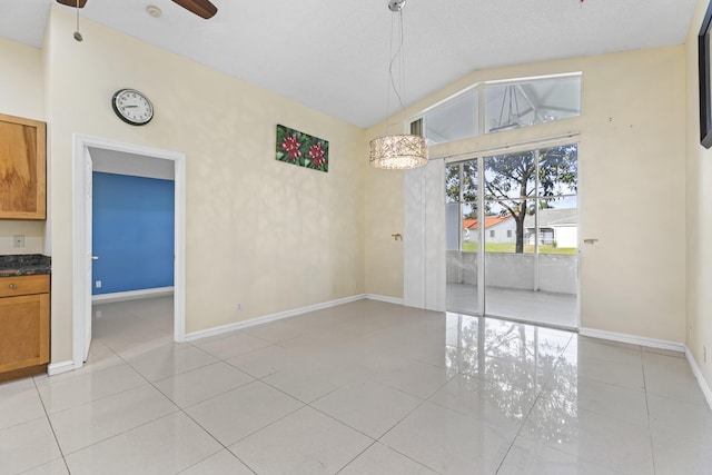 unfurnished dining area featuring ceiling fan, light tile patterned floors, and lofted ceiling