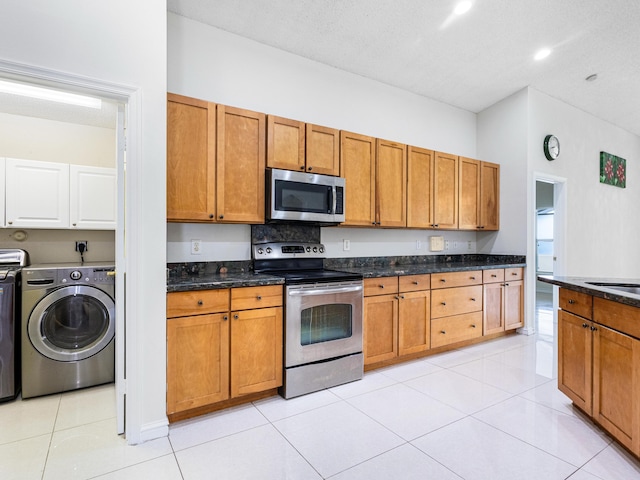 1784 Sawgrass Cir, Greenacres, FL 33413 - kitchen featuring appliances with stainless steel finishes, washer / dryer, brown cabinetry, and dark stone countertops